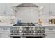 Close-up of a stainless steel range and stovetop with white cabinets and backsplash at 3185 Casteel Ne Rd, Marietta, GA 30062