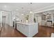 Open kitchen features an island, pendant lighting, and seamlessly flows into the living area at 3185 Casteel Ne Rd, Marietta, GA 30062