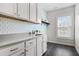 Laundry room with white cabinets, modern countertops, and a tile floor at 3185 Casteel Ne Rd, Marietta, GA 30062