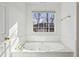 White tiled bathroom with jacuzzi tub at 3242 Monarch Pine Nw Dr, Peachtree Corners, GA 30071