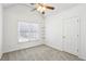 A bright bedroom is carpeted and features a ceiling fan, a window with blinds, and a convenient closet at 3242 Monarch Pine Nw Dr, Peachtree Corners, GA 30071