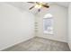 Bright bedroom featuring neutral carpet, a ceiling fan, and a window with natural light and additional shelving at 3242 Monarch Pine Nw Dr, Peachtree Corners, GA 30071