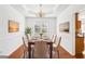 Bright dining room featuring hardwood floors, tray ceiling, wainscoting, and an elegant table setting at 3242 Monarch Pine Nw Dr, Peachtree Corners, GA 30071