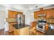 Well-appointed kitchen featuring granite countertops, wood cabinets, stainless steel appliances, and center island at 3242 Monarch Pine Nw Dr, Peachtree Corners, GA 30071
