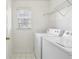 A laundry room featuring a washer and dryer, tile floor, a wire rack, and a window at 3242 Monarch Pine Nw Dr, Peachtree Corners, GA 30071