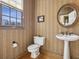 Traditional half-bathroom with pedestal sink, decorative mirror, striped wallpaper, and window at 535 Cameron Manor Way, Atlanta, GA 30328