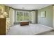 A spacious bedroom features a window, wall-to-wall carpet, curtains, a wooden chest and a light-colored painted wall at 535 Cameron Manor Way, Atlanta, GA 30328