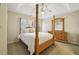 Well-lit bedroom showcasing a four-poster bed, tray ceiling, and matching dresser with mirror at 535 Cameron Manor Way, Atlanta, GA 30328