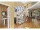 Bright foyer featuring a curved staircase, hardwood floors, and an adjacent half bathroom at 535 Cameron Manor Way, Atlanta, GA 30328