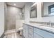 Bathroom with a double vanity, granite countertop, framed mirror, and a glass-enclosed shower at 1497 Rogers Sw Ave, Atlanta, GA 30310