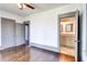 Bedroom features hardwood floors, gray trim, and a view of an en-suite bathroom at 1497 Rogers Sw Ave, Atlanta, GA 30310