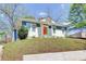 Charming home featuring an inviting orange front door, blue and white exterior, and landscaped front yard at 1497 Rogers Sw Ave, Atlanta, GA 30310