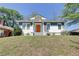 Charming home featuring an inviting orange front door, blue and white exterior, and landscaped front yard at 1497 Rogers Sw Ave, Atlanta, GA 30310