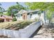 Charming home featuring an inviting orange front door, blue and white exterior, and landscaped front yard at 1497 Rogers Sw Ave, Atlanta, GA 30310