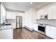 Modern kitchen showcasing white cabinets, stainless steel appliances, granite countertops, and stylish tile backsplash at 1497 Rogers Sw Ave, Atlanta, GA 30310