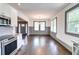 Bright, airy living room featuring hardwood floors, modern wainscoting, and a view into the kitchen and front entrance at 1497 Rogers Sw Ave, Atlanta, GA 30310