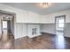 Cozy living room featuring hardwood floors, wainscoting, a painted fireplace, and view to another room at 1497 Rogers Sw Ave, Atlanta, GA 30310