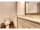 This powder room features a granite countertop, a wood-framed mirror, and modern fixtures at 1497 Rogers Sw Ave, Atlanta, GA 30310