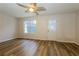 Bright living room featuring durable wood-look floors, ceiling fan, and glass paneled exterior door at 8409 Carlington Ln, Jonesboro, GA 30236