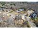 An aerial view shows the neighborhood with mature trees, tennis court, and well maintained homes at 1540 Turtle Pond Dr, Hoschton, GA 30548