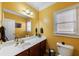 Bright bathroom with yellow walls, large mirror and custom vanity at 1540 Turtle Pond Dr, Hoschton, GA 30548