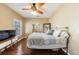 Bedroom showcasing a hardwood floor, ceiling fan, and a large window at 1540 Turtle Pond Dr, Hoschton, GA 30548