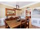 Warm dining area with a wooden table, hardwood floors, and stylish lighting, perfect for Gathering gatherings at 1540 Turtle Pond Dr, Hoschton, GA 30548