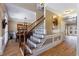 Elegant foyer showcasing hardwood floors, decorative staircase, and dining area, creating a welcoming ambiance at 1540 Turtle Pond Dr, Hoschton, GA 30548