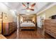 Spacious main bedroom with hardwood floors, wood furniture, and a fan at 1540 Turtle Pond Dr, Hoschton, GA 30548
