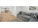 Basement living area with a comfortable gray couch, throw pillows, and wood floors at 7410 Fields Dr, Cumming, GA 30041