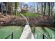 Quaint footbridge spanning a waterway, connecting the property with the main house, surrounded by lush greenery at 7410 Fields Dr, Cumming, GA 30041