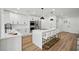Modern kitchen with a large island with barstool seating, stainless steel appliances and stylish fixtures at 7410 Fields Dr, Cumming, GA 30041