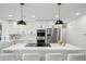 Modern kitchen with a large island and barstool seating featuring stainless steel appliances and fixtures at 7410 Fields Dr, Cumming, GA 30041