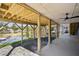 View of covered patio with lake view featuring wood beams, concrete flooring, and ceiling fan at 7410 Fields Dr, Cumming, GA 30041