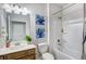 Bright bathroom featuring tub shower, white vanity and a floral painting at 112 Asher Dr, Carrollton, GA 30116