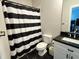 Modern bathroom featuring a sleek vanity with black countertop and a shower with a black and white curtain at 1775 Rockwater Rd, Marietta, GA 30066