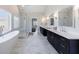 Spacious bathroom showcasing dual vanities, a free-standing tub, a frameless glass shower, and marble flooring at 1775 Rockwater Rd, Marietta, GA 30066