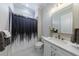 Bathroom with modern fixtures, white vanity, decorative mirror, and a shower with stylish curtain at 1775 Rockwater Rd, Marietta, GA 30066