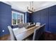 Sophisticated dining room with blue paneled walls, hardwood floors, and elegant table setting at 1775 Rockwater Rd, Marietta, GA 30066