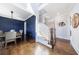 Bright foyer featuring hardwood floors, a staircase, and stylish dining room with blue paneled walls at 1775 Rockwater Rd, Marietta, GA 30066