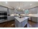 Modern kitchen boasts gray cabinets, stainless steel appliances, and a large island with pendant lighting at 1775 Rockwater Rd, Marietta, GA 30066