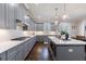 Modern kitchen with gray cabinets, stainless steel appliances, island, and pendant lights over hardwood floors at 1775 Rockwater Rd, Marietta, GA 30066