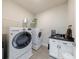 Well-equipped laundry room featuring a utility sink, modern washer and dryer, and convenient storage shelves at 1775 Rockwater Rd, Marietta, GA 30066