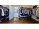 Walk-in closet with wood floors, multiple rows of shelving, and a doorway to the primary bathroom at 1775 Rockwater Rd, Marietta, GA 30066