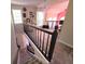 Upper landing with carpeted stairs, black railings, and views of a loft area with stylish decor and lighting at 2270 Goodwood Se Blvd, Smyrna, GA 30080