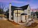 Stunning new construction home boasts a modern design, with a white brick facade and black accents at 56 Pine St, Roswell, GA 30075