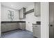 Functional laundry room with gray cabinets, dark countertop, and herringbone floors at 56 Pine St, Roswell, GA 30075