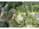 Aerial view of a home surrounded by mature trees, lush lawn, and private driveway, exuding tranquility at 59 Woodlawn Dr, Marietta, GA 30067