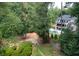 Expansive backyard featuring mature trees, manicured hedges, and a large pool with a modern home in the background at 59 Woodlawn Dr, Marietta, GA 30067