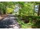 Long driveway leading to a home nestled among mature trees and lush landscaping at 59 Woodlawn Dr, Marietta, GA 30067